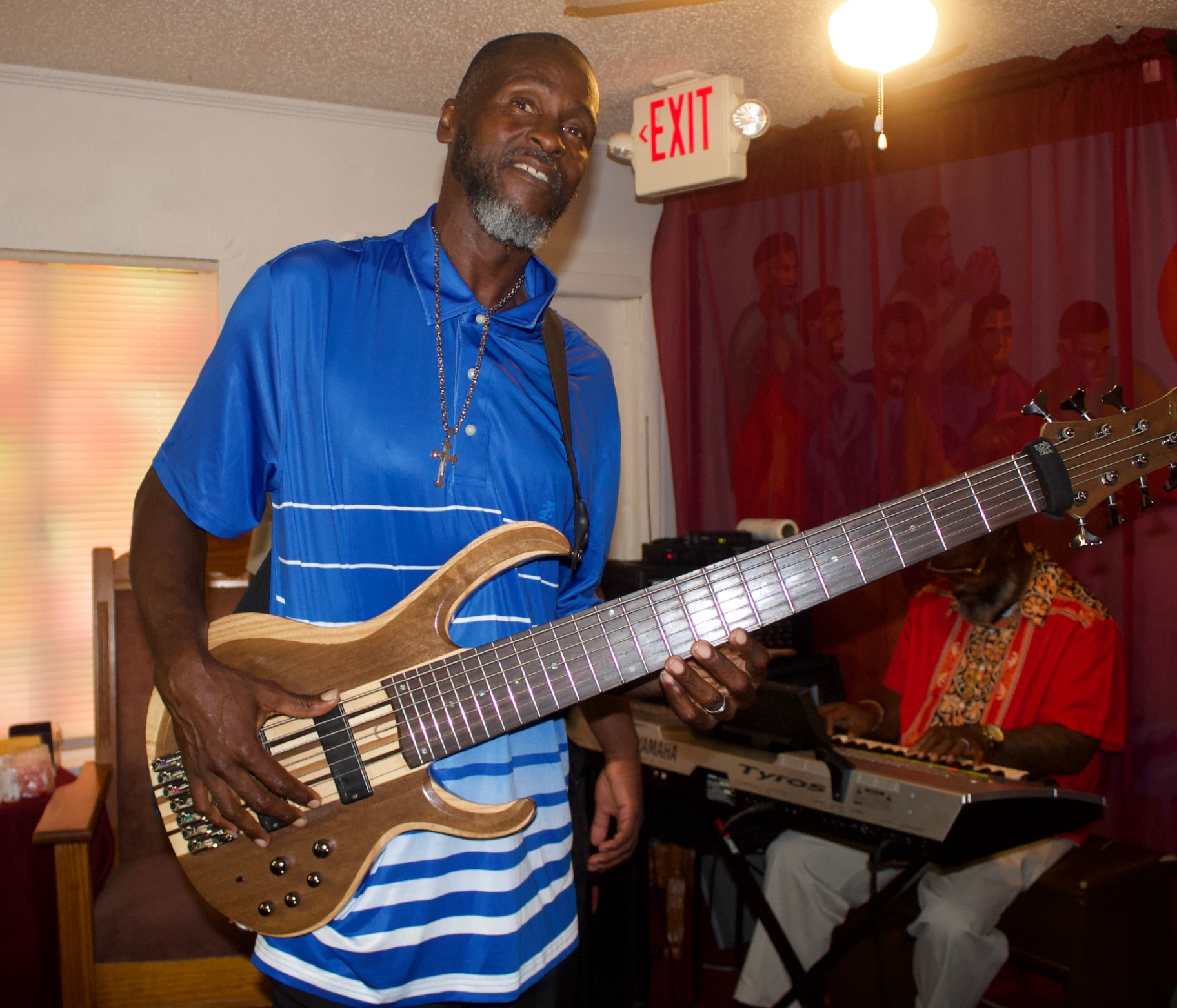 A bassist playing his instrument with joy during worship service