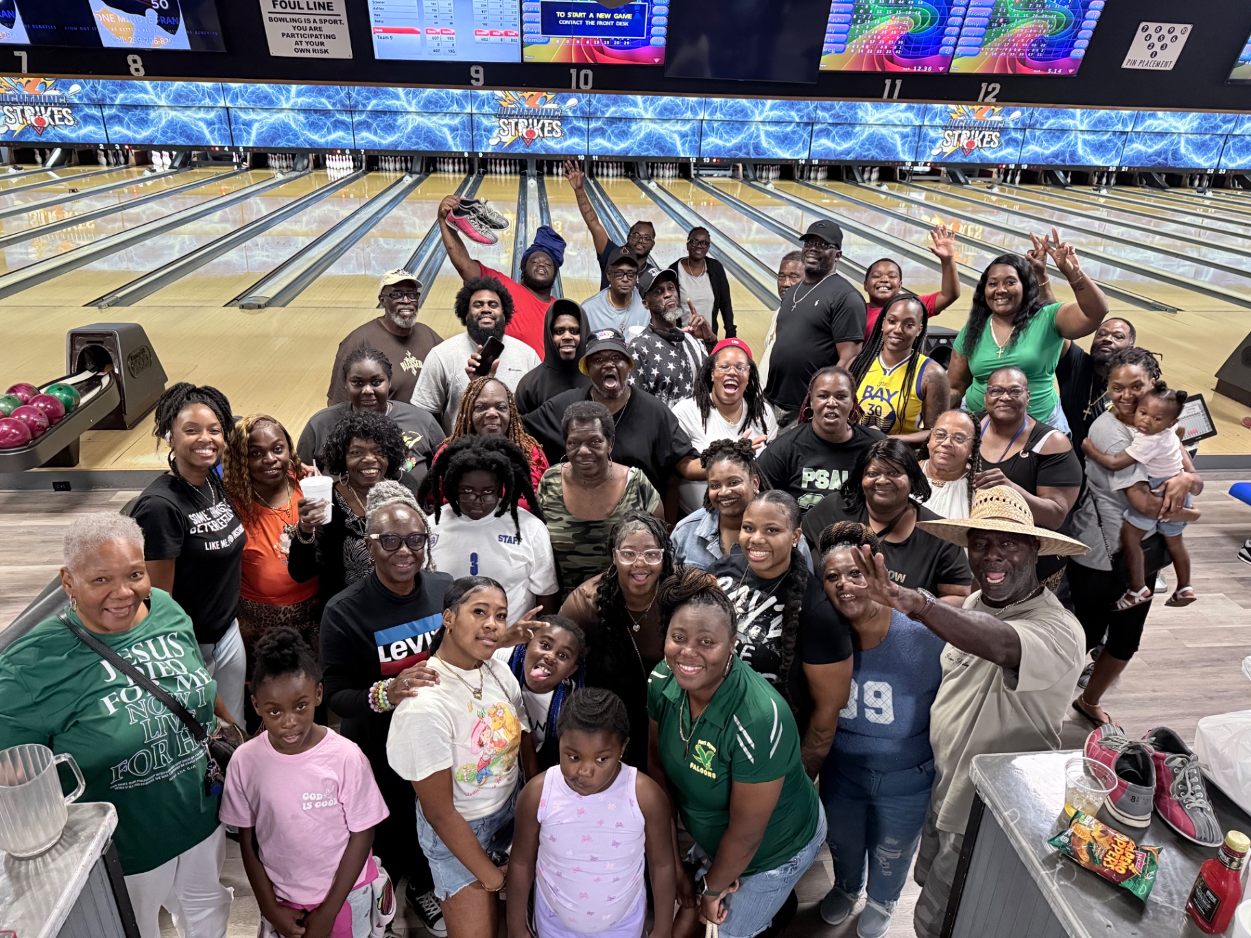 A large group of church members and families gathered at a bowling alley for Bible study fellowship