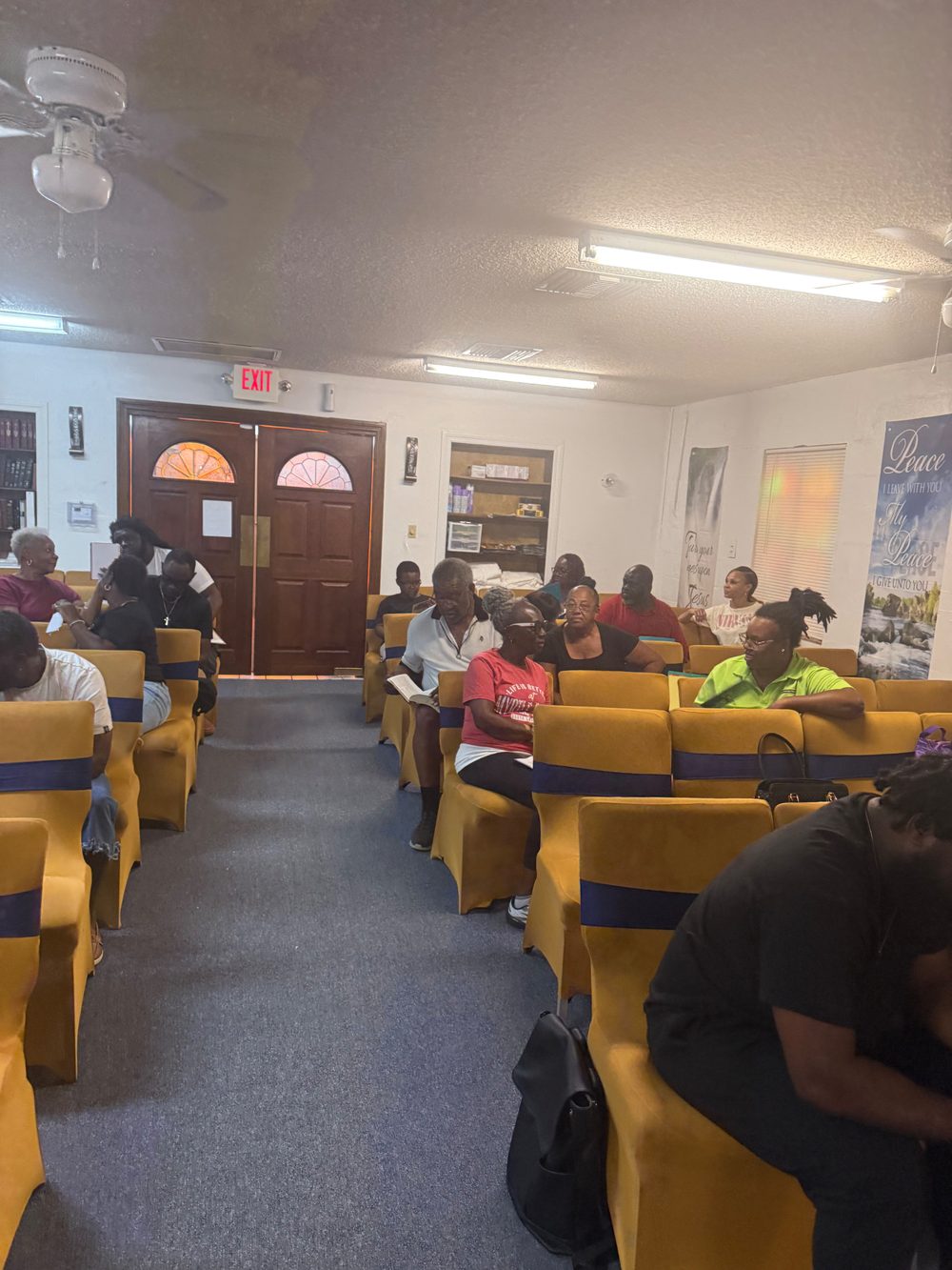 The church family seated in rows of chairs listening to the Word during Bible study