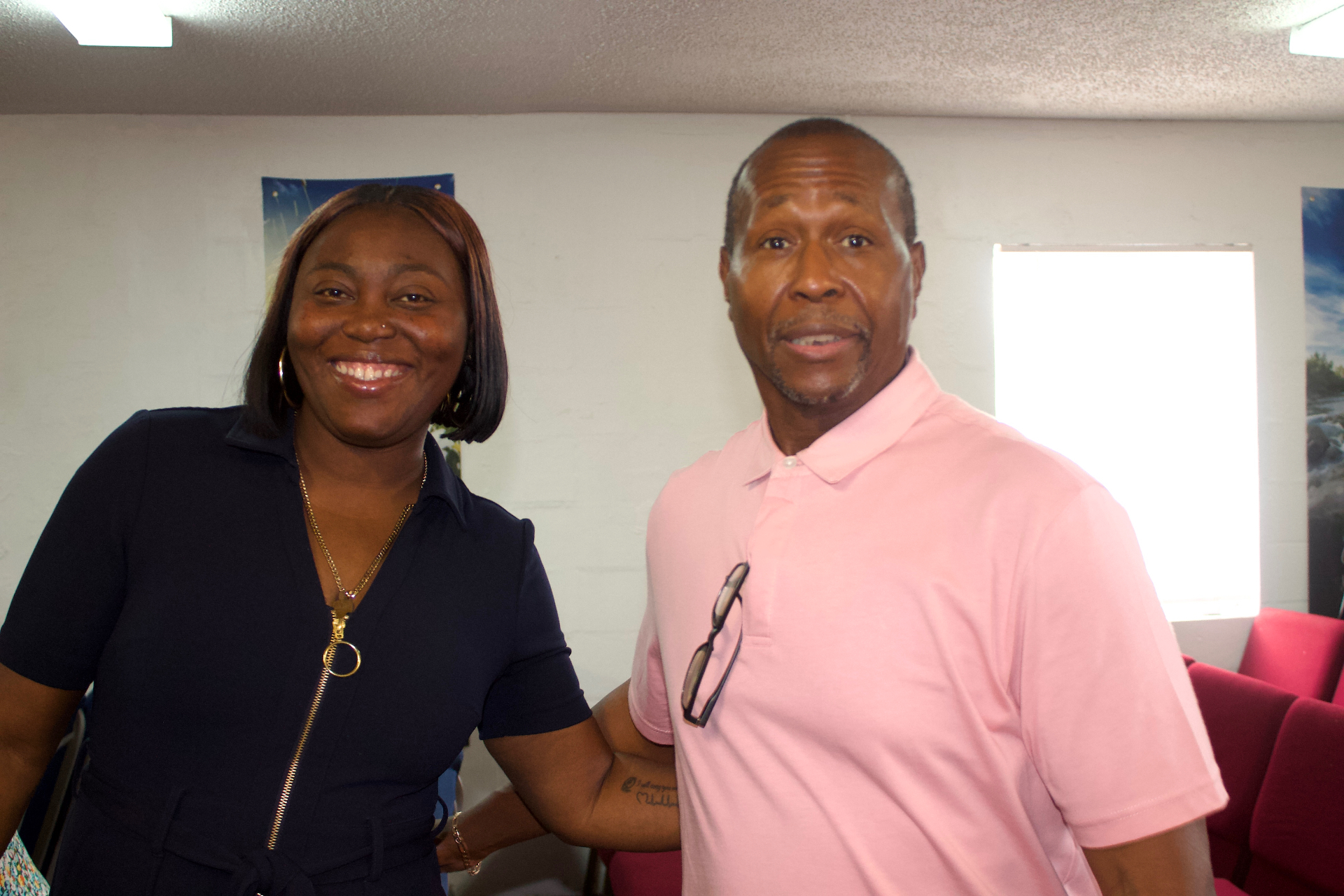 A man and woman smiling together while standing in the church sanctuary
